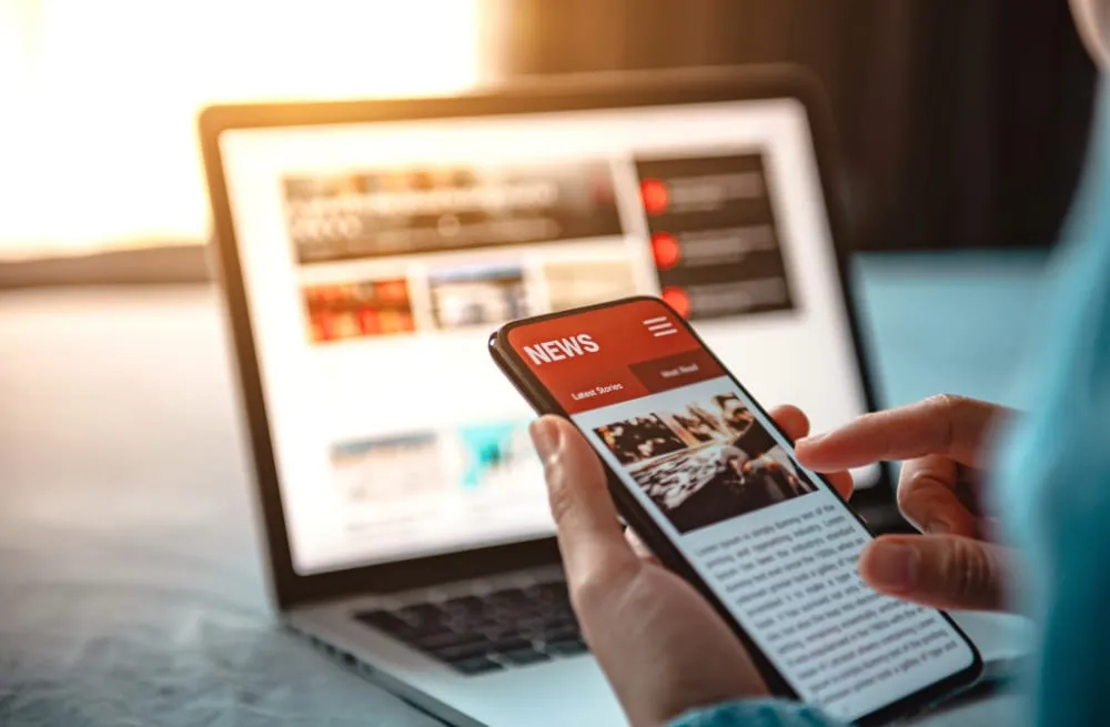 Aplikasi web dan mobile ditampilkan berdampingan di laptop dan ponsel